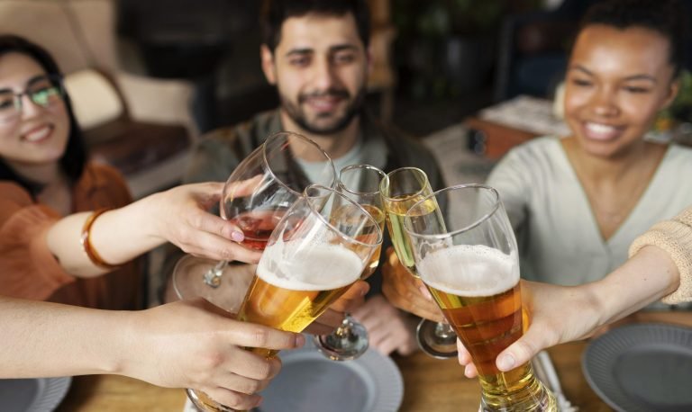 close-up-friends-clinking-glasses-scaled-e1765905288113-768x458